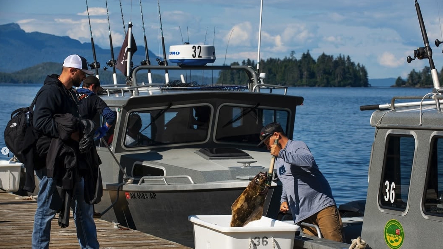 Two men on dock packaging fish.