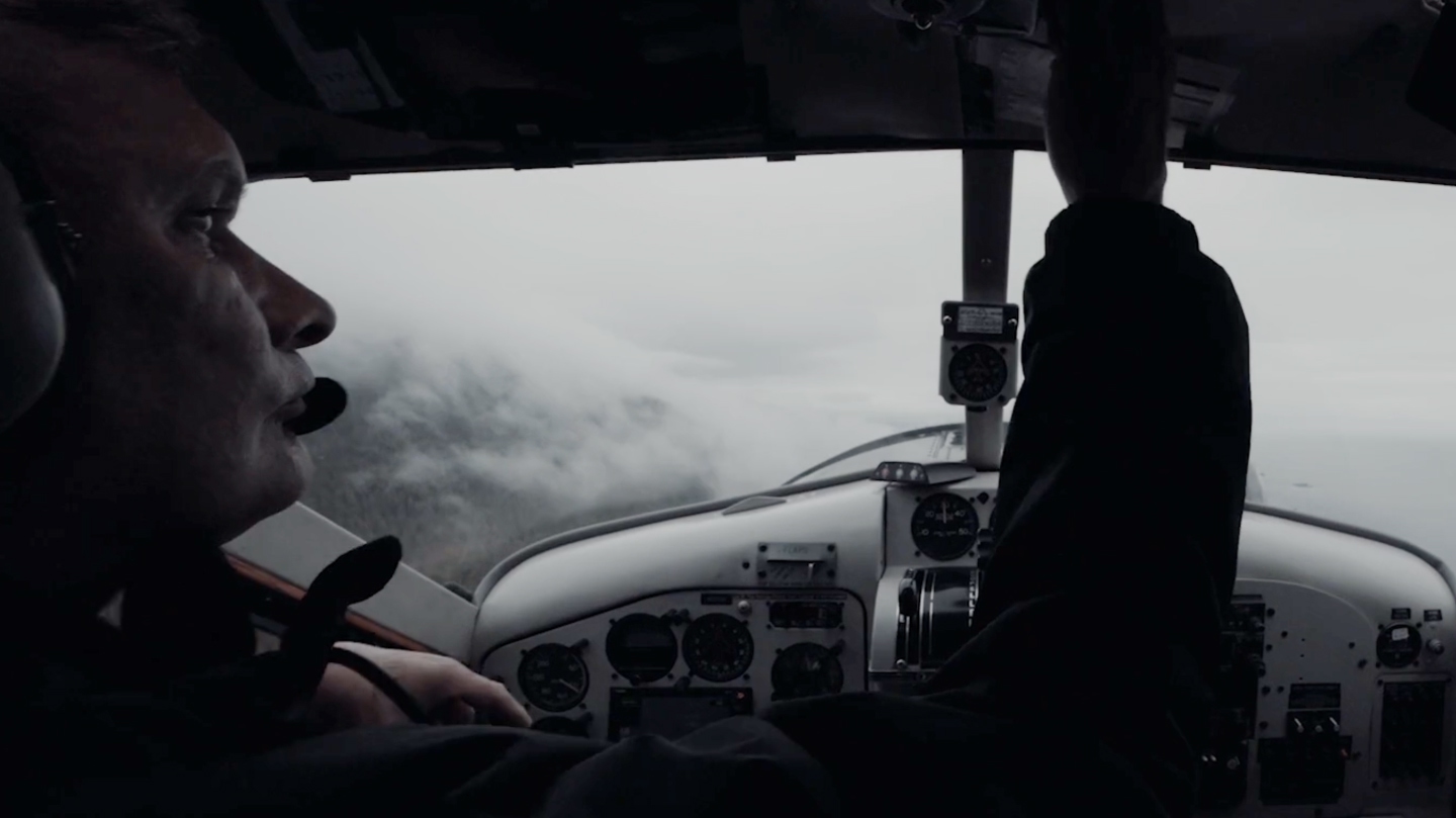 Pilot flying a plane in cloudy weather.