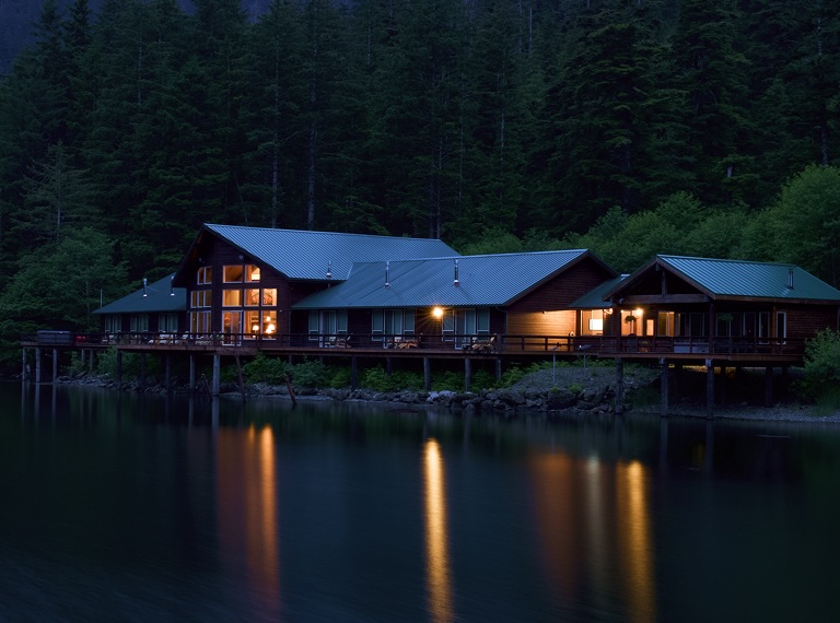 the lodge at night with lights reflecting on the water